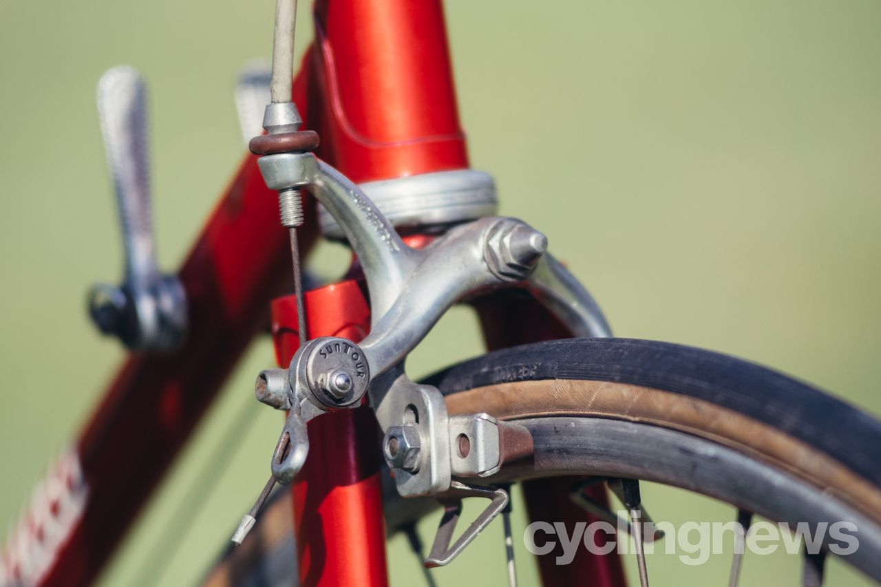 Close up of a front rim brake on a vintage red bike