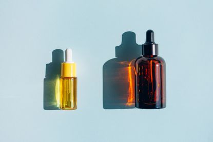 two serums against a blue background, to illustrate hyaluronic acid vs retinol serum