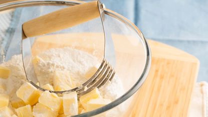 What is a pastry blender? A handheld pastry blender in a bowl with cubes of butter and flour
