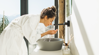 Woman splashing her face with water