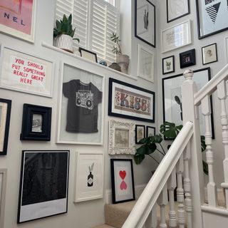 White staircase lined with framed artwork