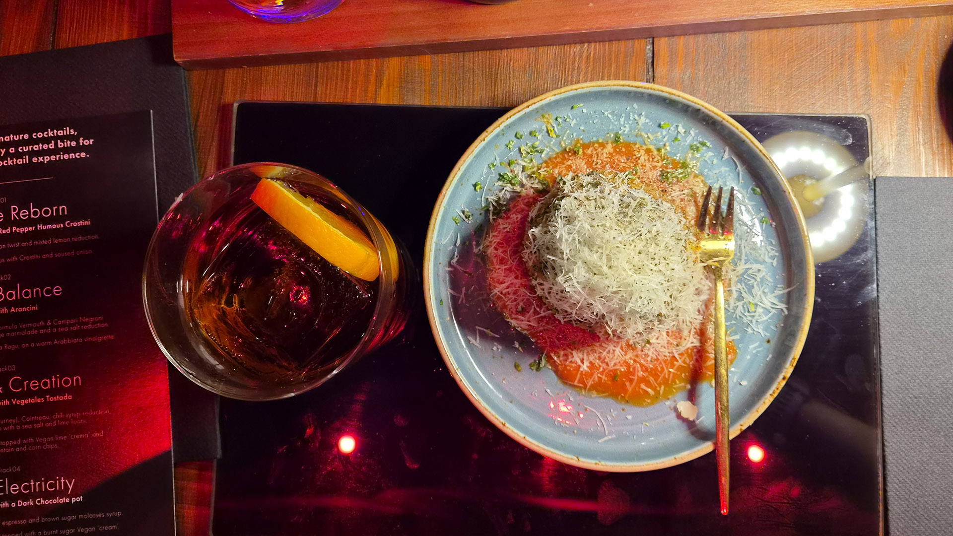 A photo of a plate of food and cocktail.