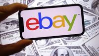 POLAND - 2025/11/16: In this photo illustration, the eBay company logo is seen displayed on a smartphone screen with United States dollar banknotes in the background. (Photo Illustration by Piotr Swat/SOPA Images/LightRocket via Getty Images)