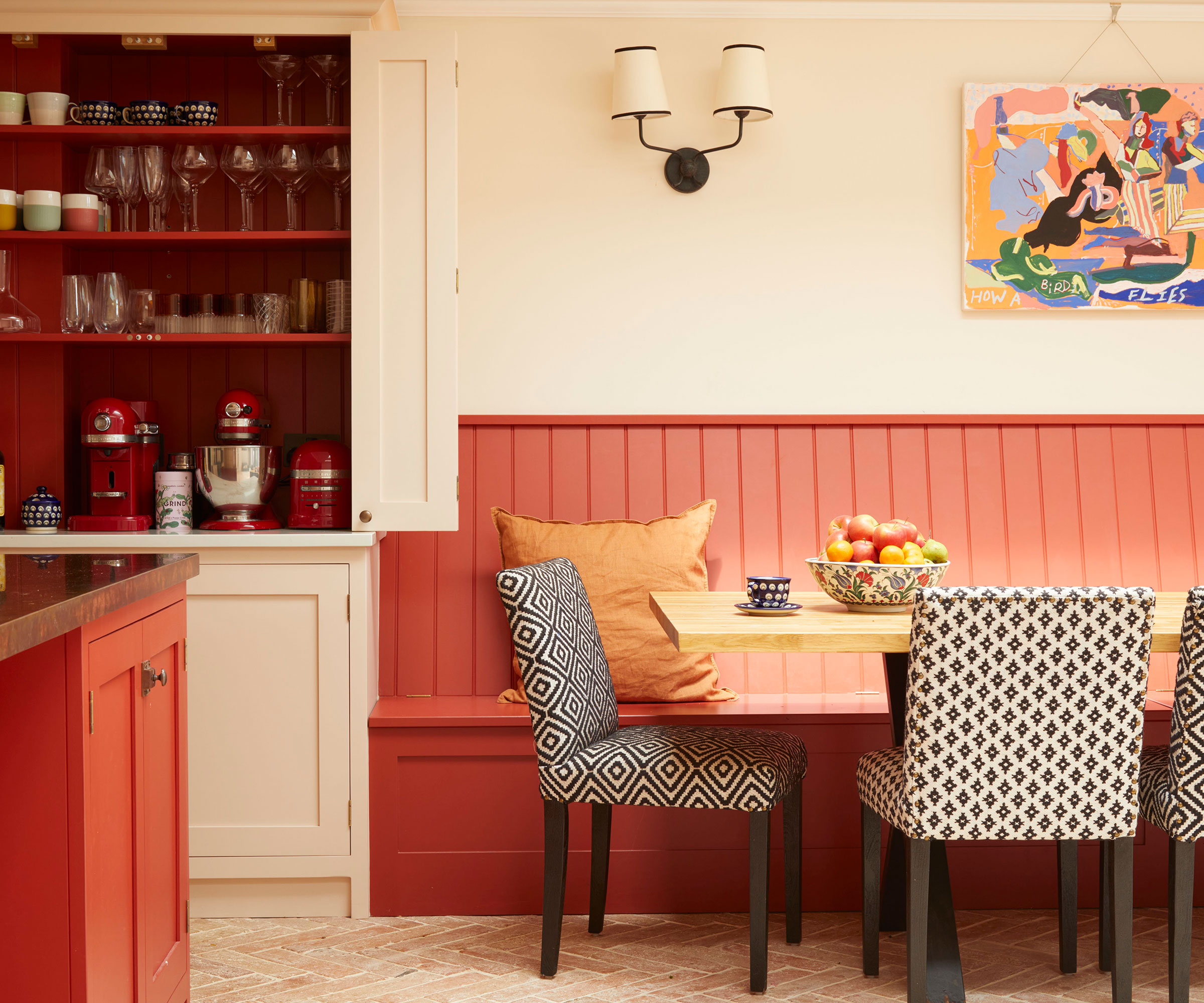 red kitchen with banquette seating and larder unit