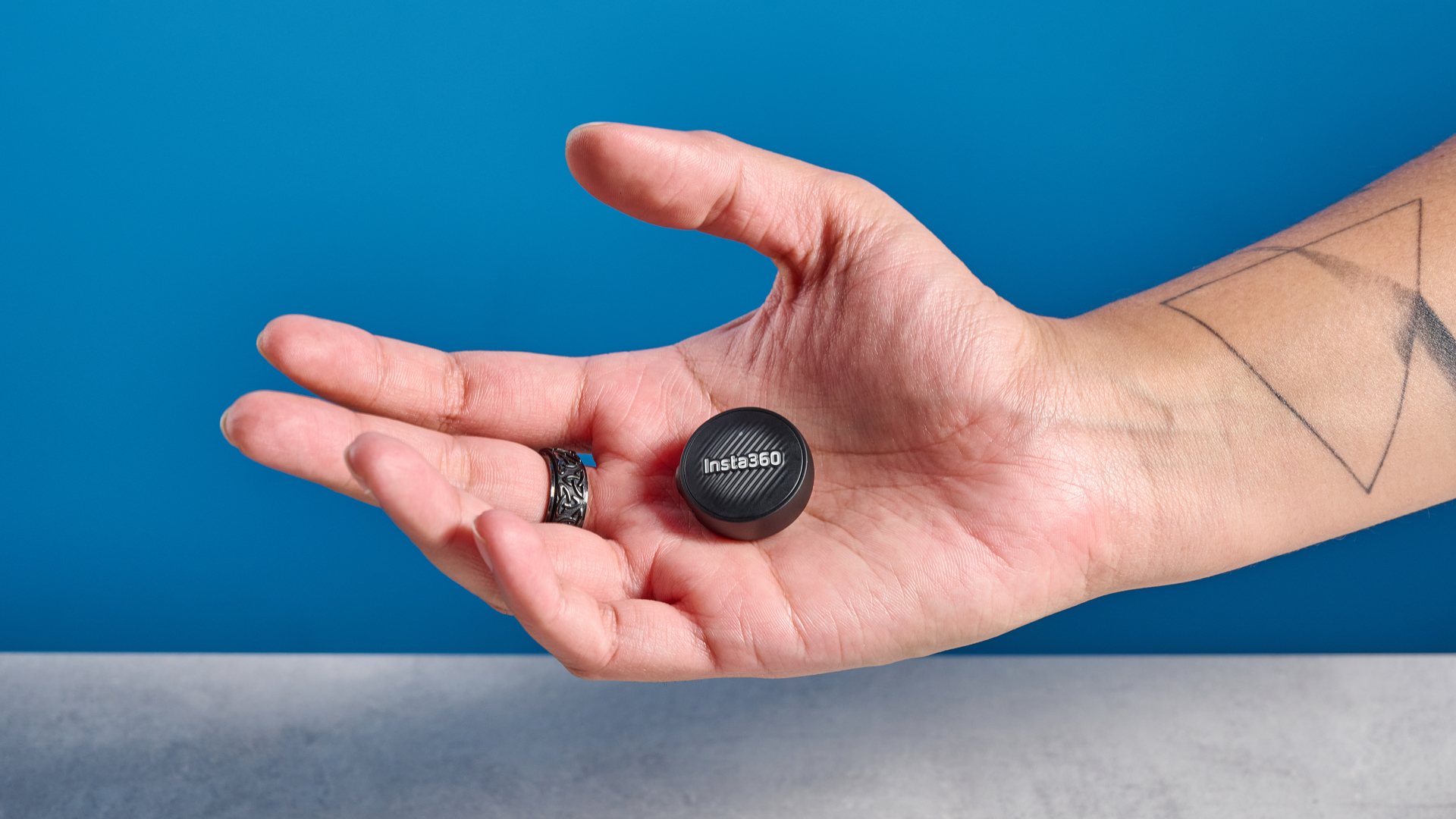 Insta360 Mic Air photographed on a blue background