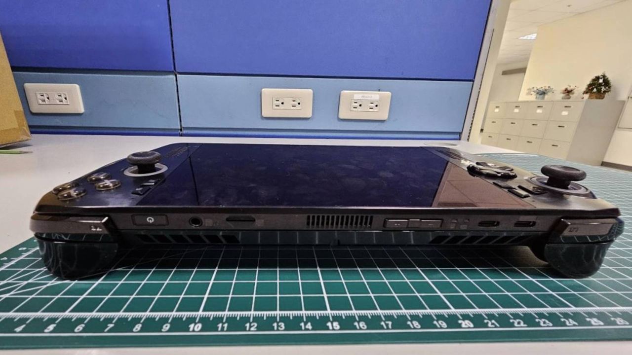Xbox handheld in black lying on green cutting mat with top facing forward.