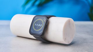 a black fitness tracker Amazfit Bip 5 showing the default yellow and blue toned watch face and fitness capabilities