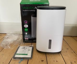 MeacoDry Arete One 20L Dehumidifier box beside the dehumidifier and other unboxing accessories