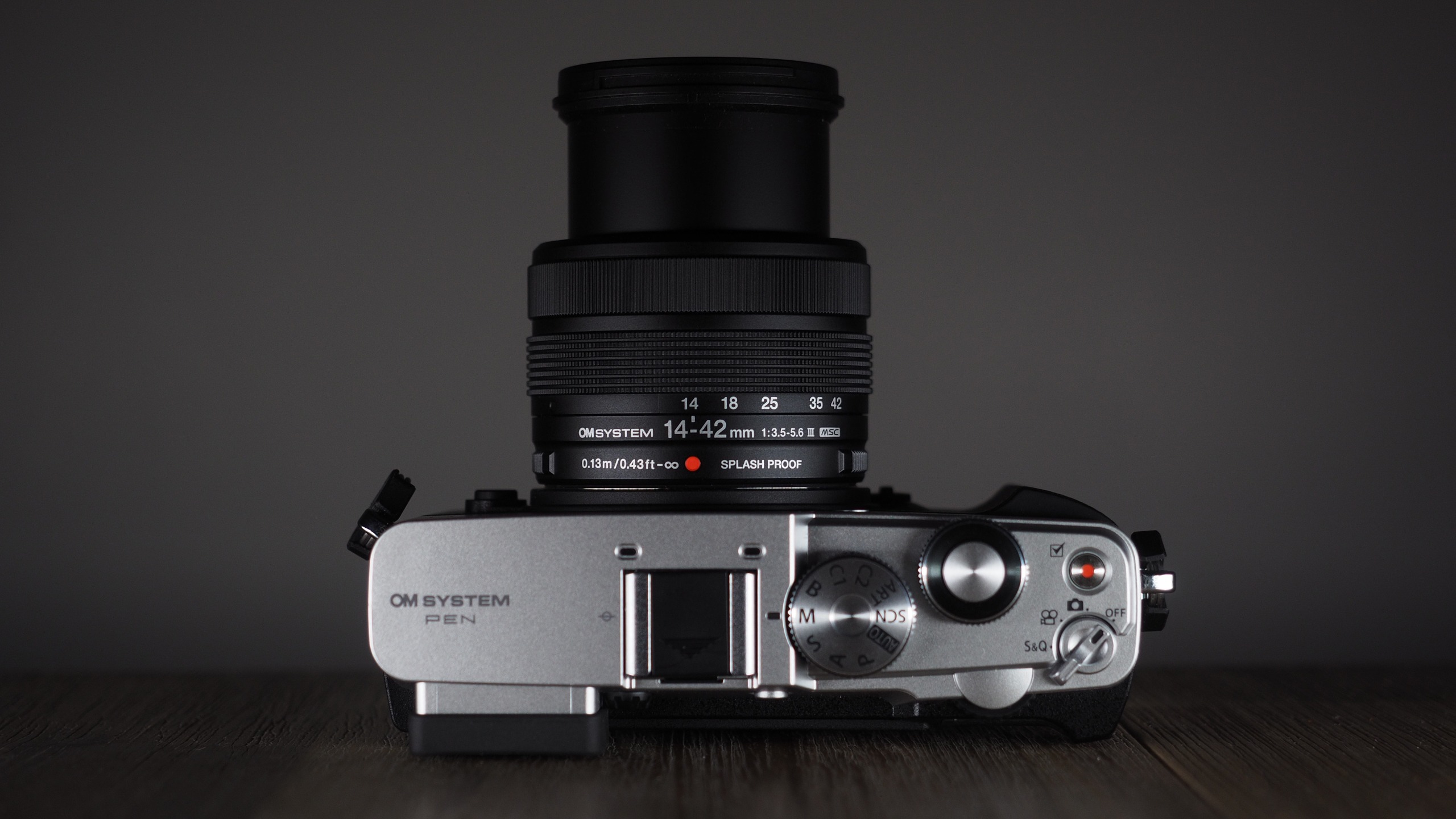 OM System OM-3 with the OM System M.Zuiko 14-42mm 3.5-5.6 III on a wooden surface