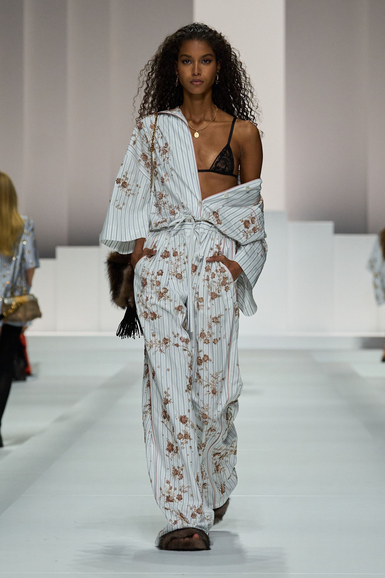 A model on dolce & Gabbana runway wears a pajama-inspired outfit with flroals.