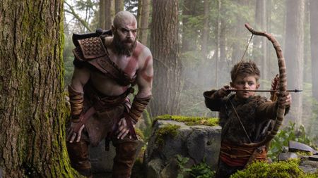 Ryan Hurst's Kratos crouching near Atreus (Callum Vinson) in first look at God of War series