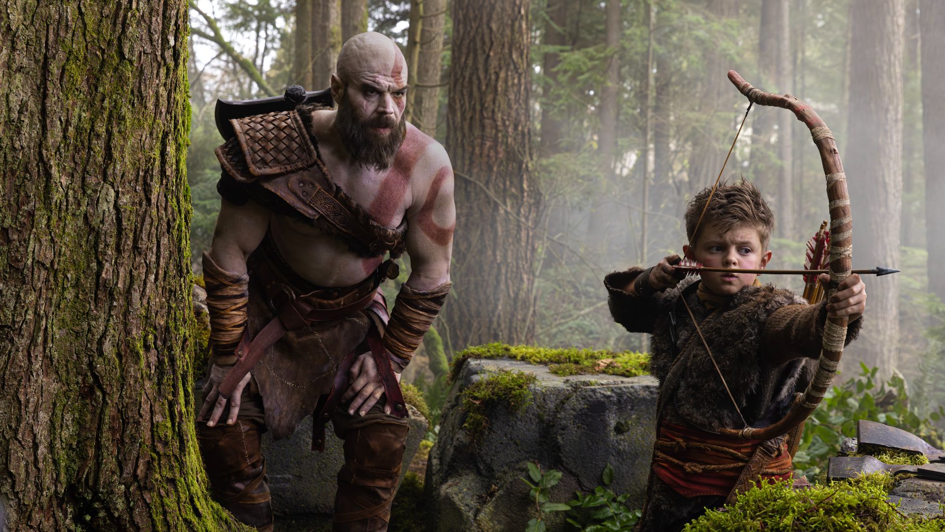 Ryan Hurst's Kratos crouching near Atreus (Callum Vinson) in first look at God of War series