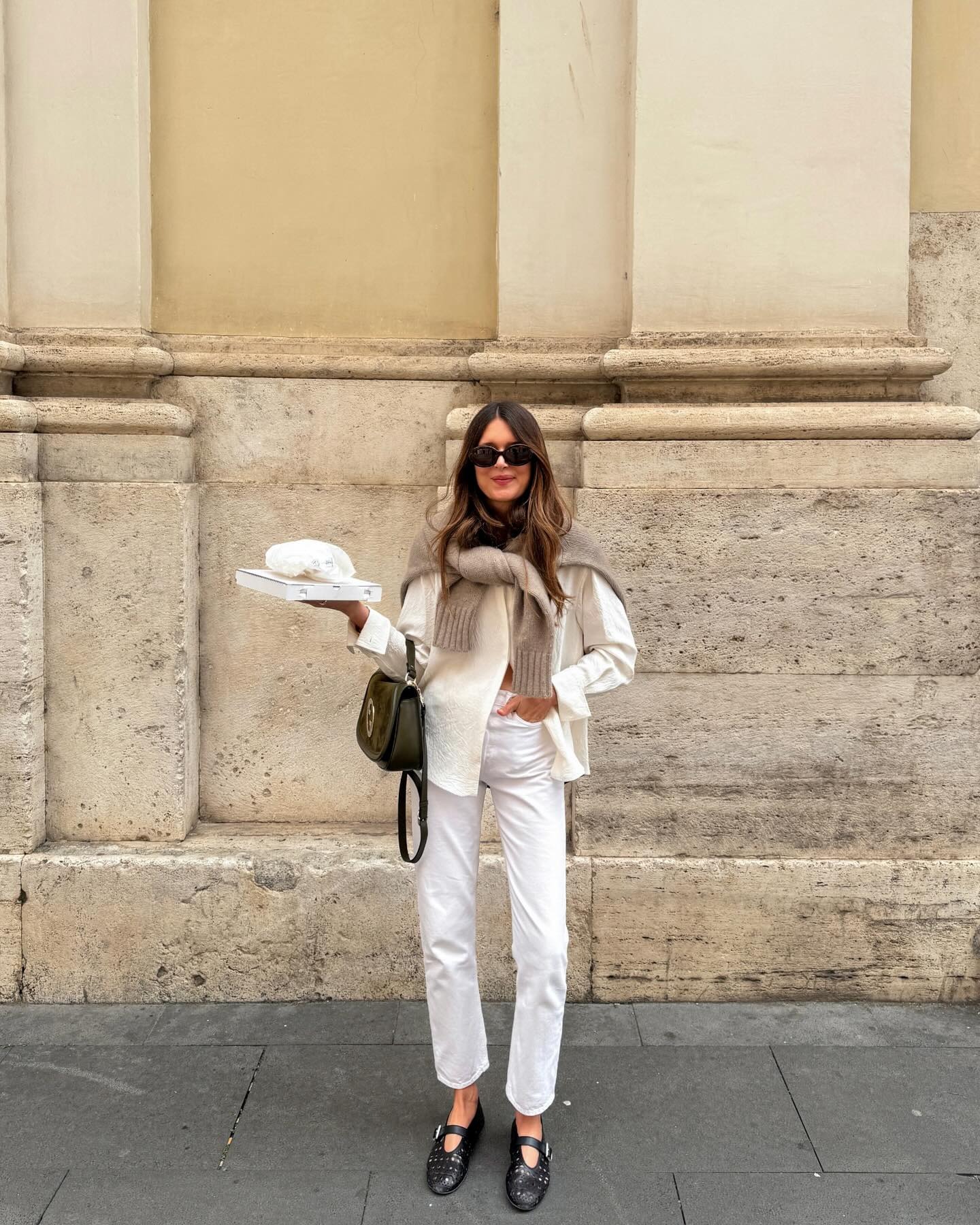 Woman in white jeans, white skirt, and sweater.