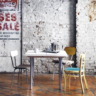 Upcycled dining table made with scaffolding materials with three different shape chairs