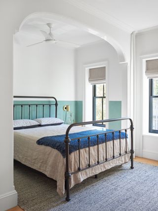a bedroom with half painted wall in blue