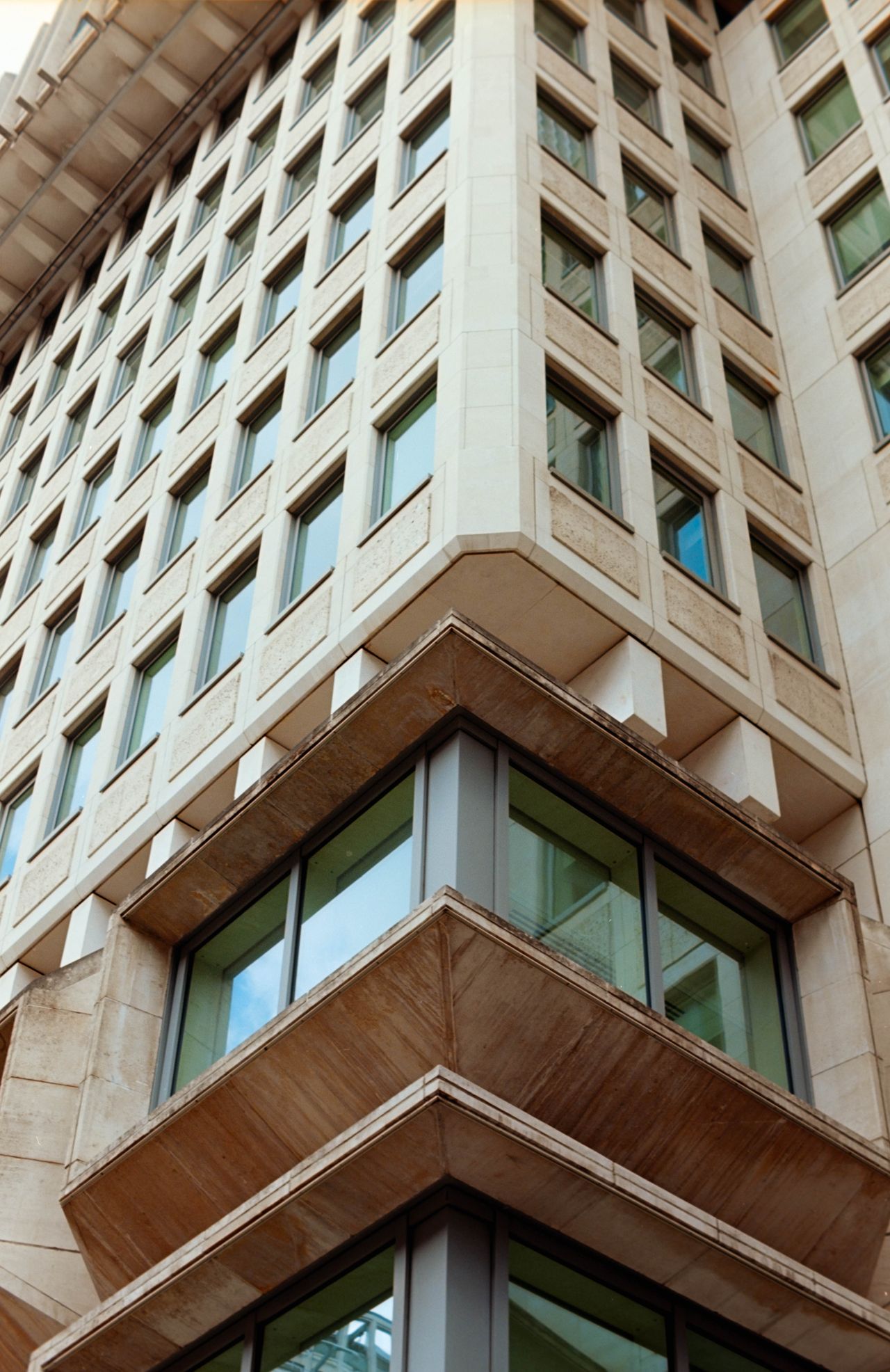 Scanned and digitized film image, using Valoi Easy 35 Pro V2 and Negative Lab Pro Lightroom plugin. Image shows a tall brutalist building seen from below