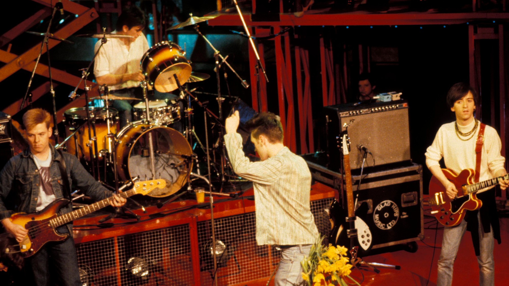 Photo of Mike JOYCE and SMITHS and MORRISSEY and Andy ROURKE and Johnny MARR; L-R: Andy Rourke, Mike Joyce (drums), Morrissey, Johnny Marr (playing Gibson ES-335 guitar), performing live on The Tube