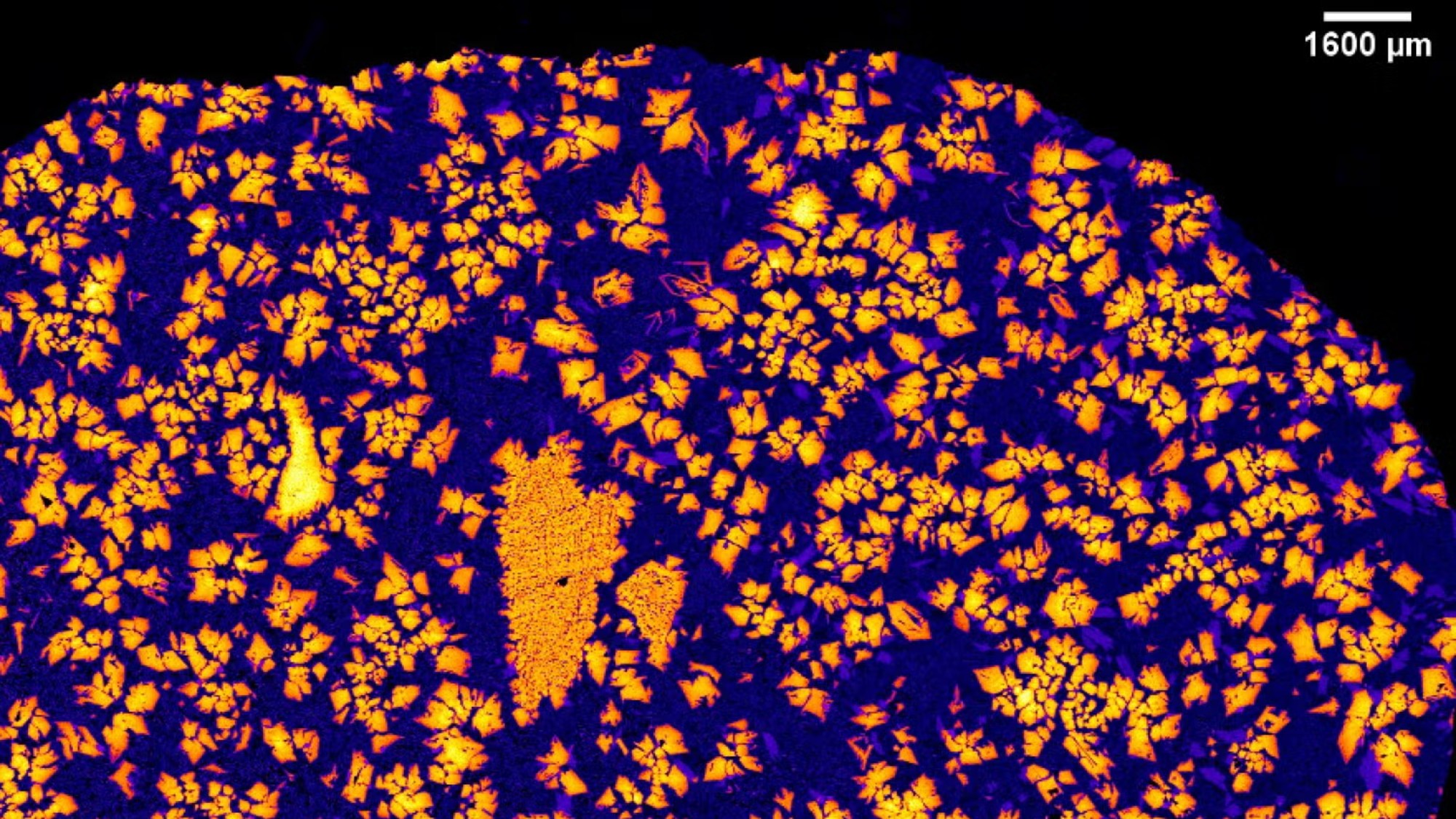 jagged flecks of brightly colored minerals on a dark background