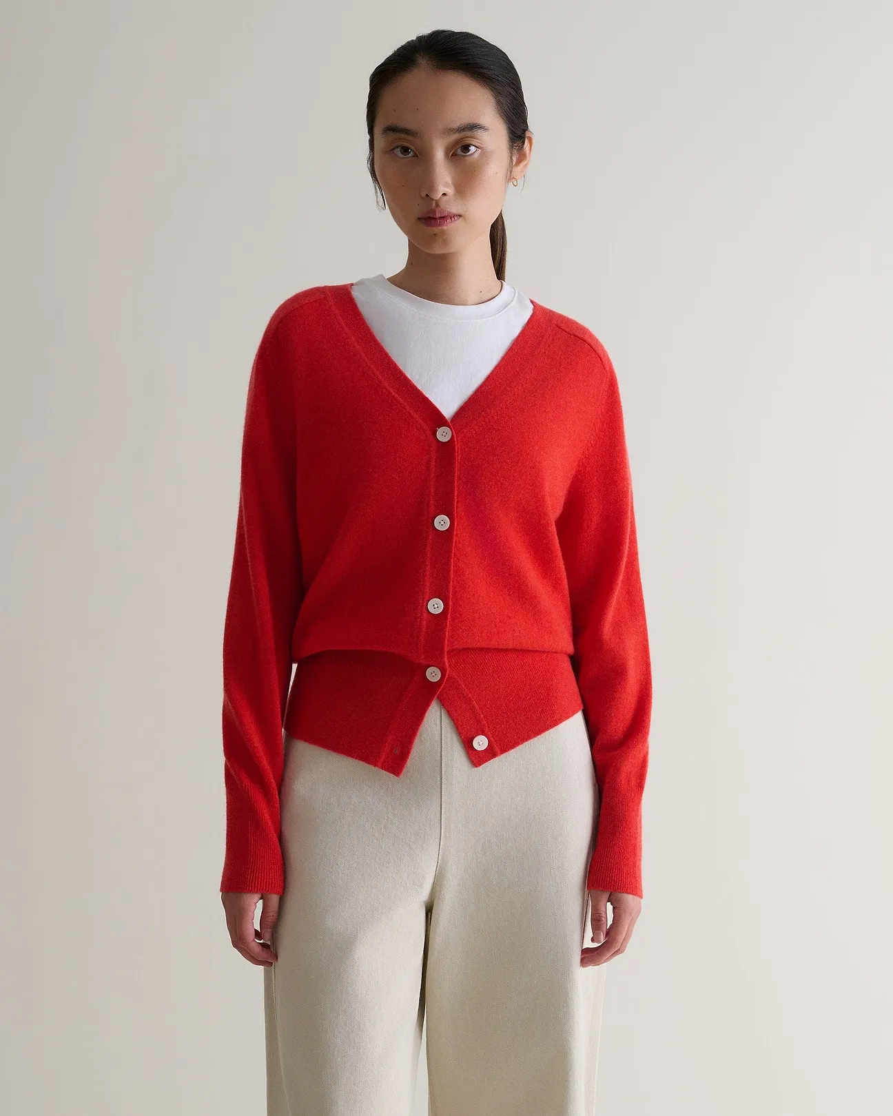 A model wears a red Rise & Fall cardigan.