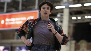  Alexandra Roach's cyber security expert, wearing purple t shirt, runs through a train station in BBC TV thriller Nightsleeper