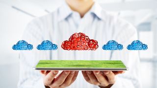 man holding small grass floor with four blue clouds and one red cloud hovering above