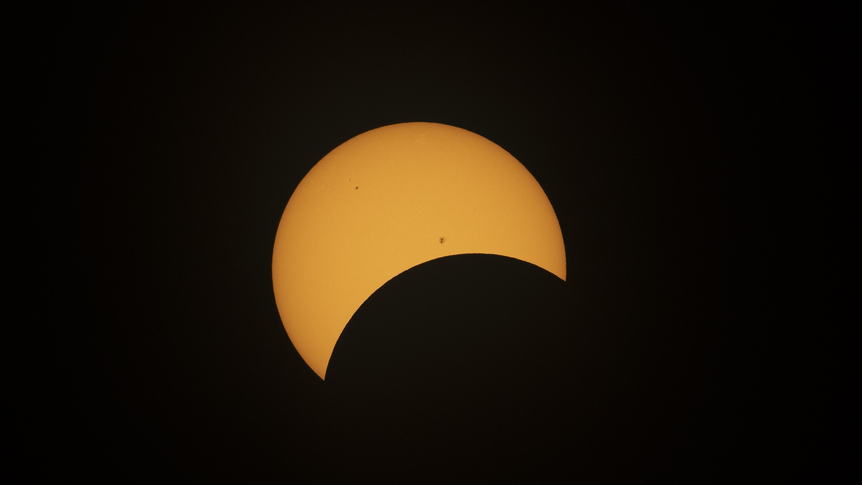 close up view of sun during the partial phase of solar eclipse there are several dark regions on the sun, these are sunspots.
