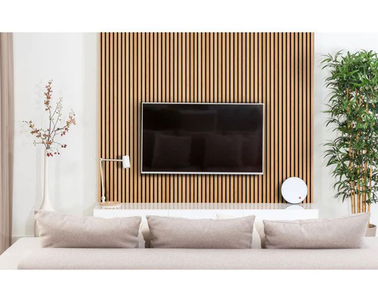 A large flat screen TV on wall against strips of acoustic wood paneling