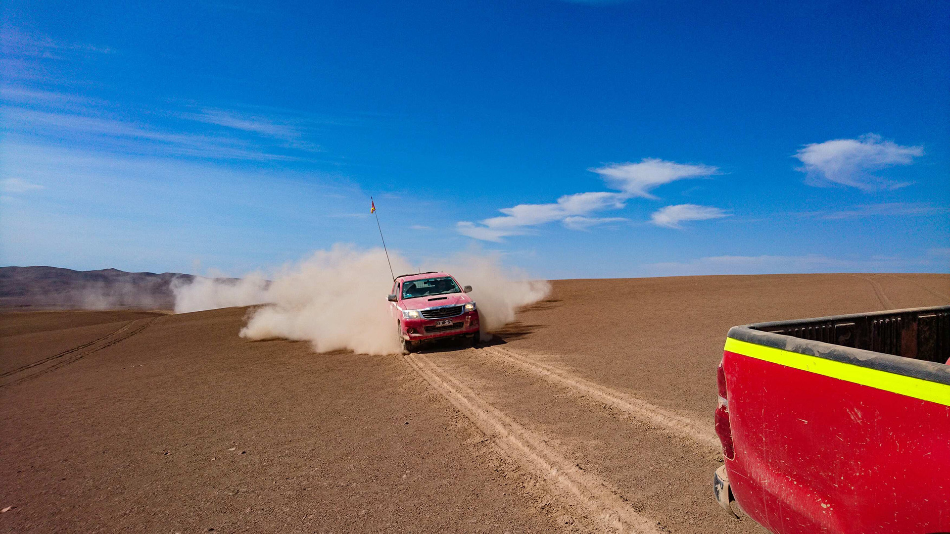 Shots from research happening in the desert, like a truck kicking up dust or a person climbing with rope down the side of a cliff.