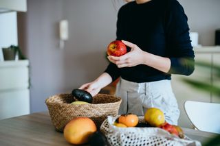 Young woman looking at fruits and vegetables to eat on the diverticulitis diet