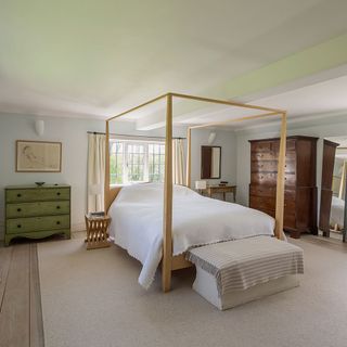 bedroom with four poster bed and french windows