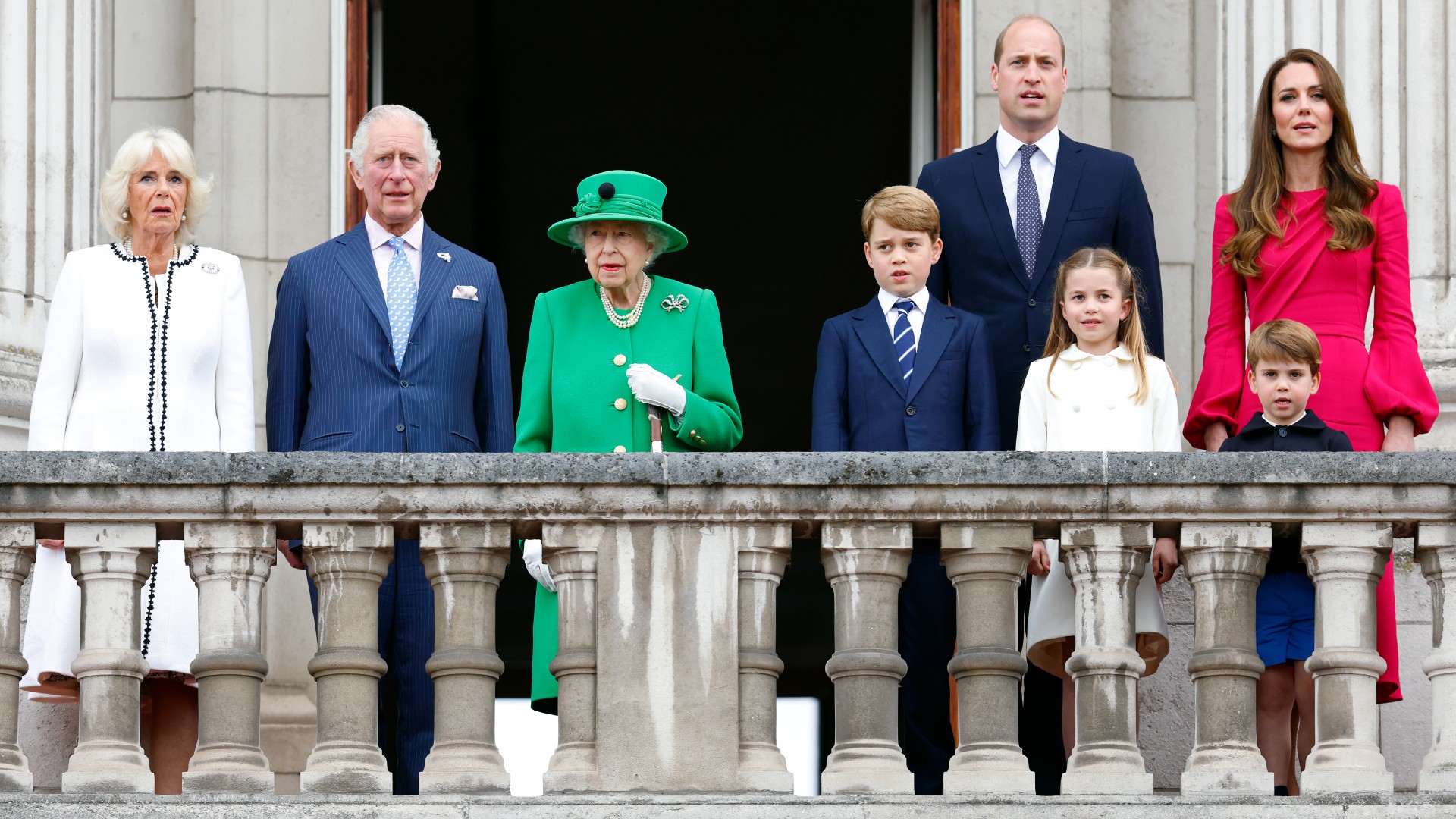 Camilla, vévodkyně z Cornwallu, princ Charles, princ z Walesu, královna Alžběta II., princ George z Cambridge, princ William, vévoda z Cambridge, princezna Charlotte z Cambridge, princ Louis z Cambridge a Catherine, vévodkyně z Cambridge stojí na balkóně Buckinghamu Palác