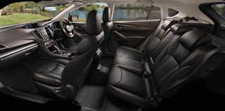 Daytime image of a XV E-Boxer Subaru plug-in hybrid interior, black leather seats, centre console, dash board and steering wheel, white roof lining, surrounding view of grass lawn, fishing lake, wooden r=tables and benches, fisherman, trees and shrubs, blue sky