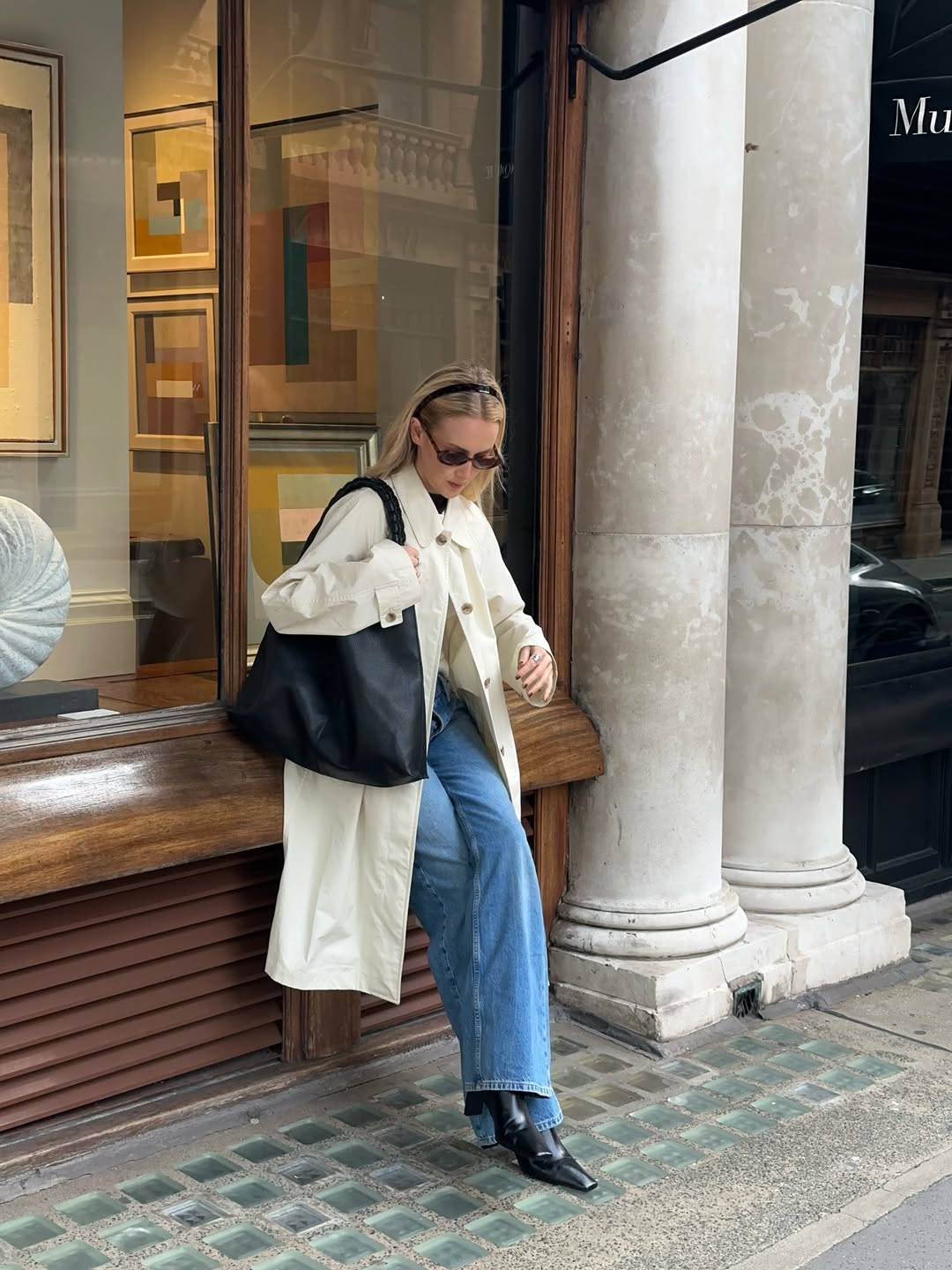 @chloekathbutler wears jeans, black boots, cream coat