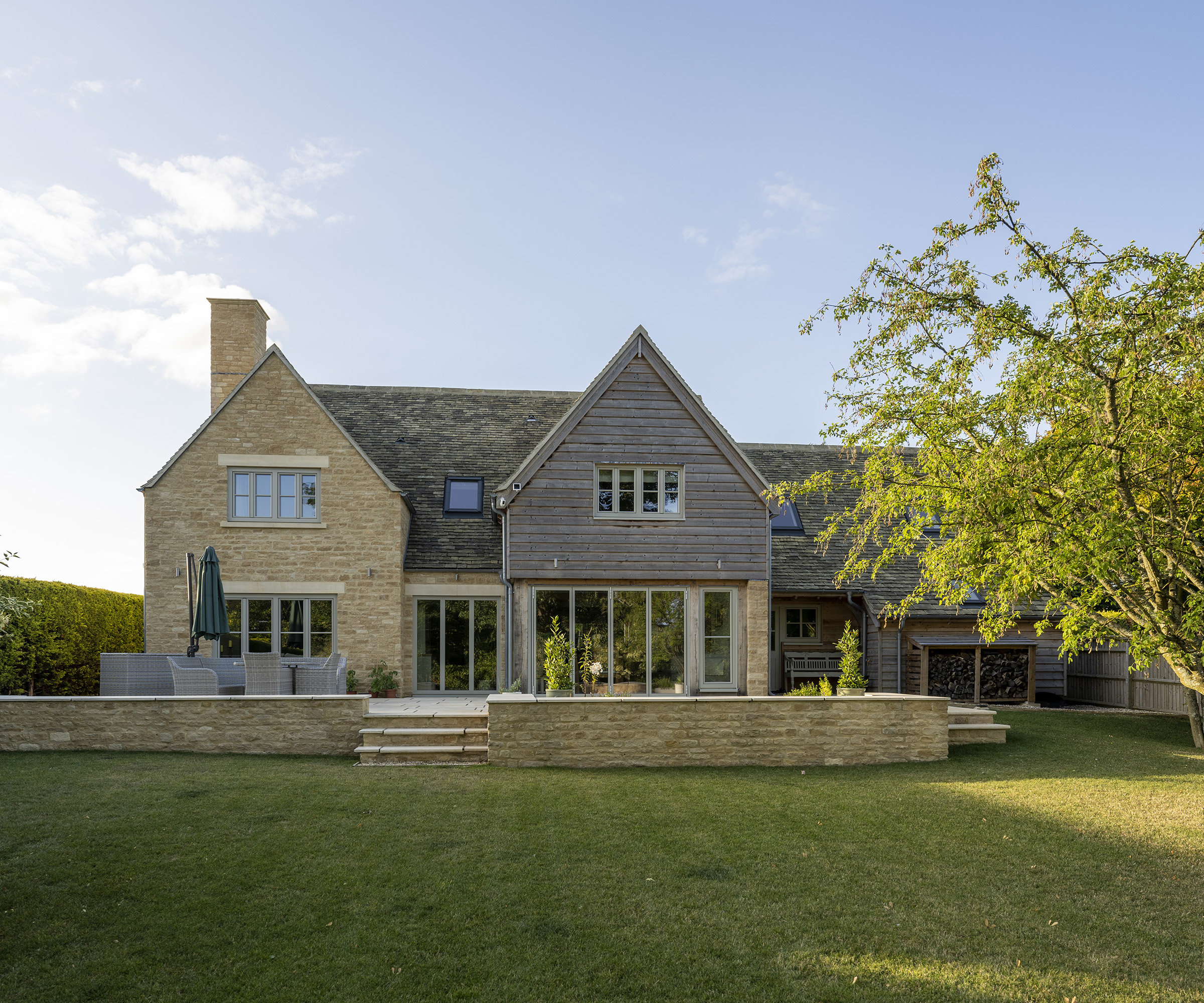 The rear exterior of an oak frame self build with timber and brick cladding