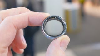 The VIV Ring in between a user's index finger and thumb shown on the show floor at CES 2025 in silver