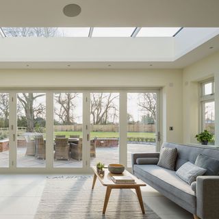 lounge with folding glass doors and grey sofa with cushions