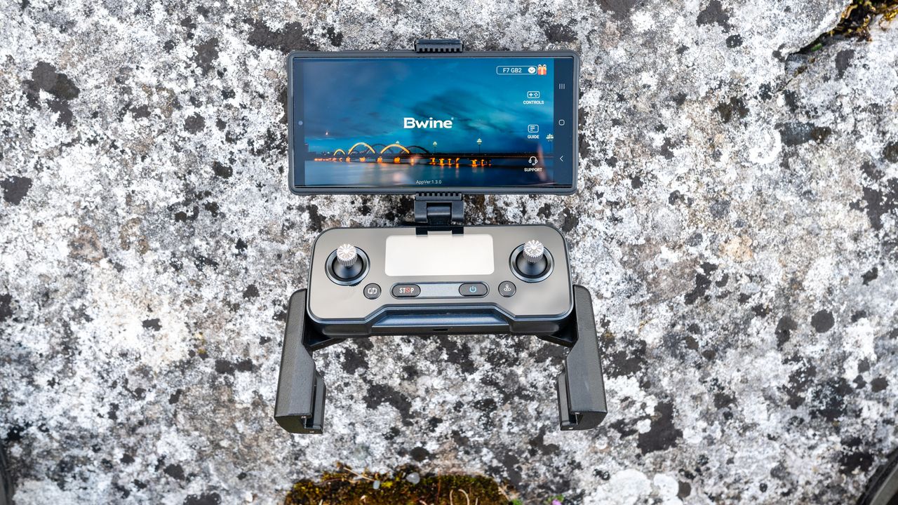 The drone controller with a smartphone attached to the top sat on a rocky surface.
