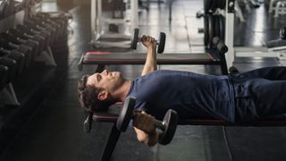 a photo of a man doing a dumbbell fly