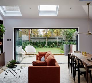 Open plan living room with sofa and view onto garden