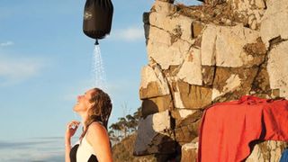 Woman using Sea to Summit Pocket Camping Shower