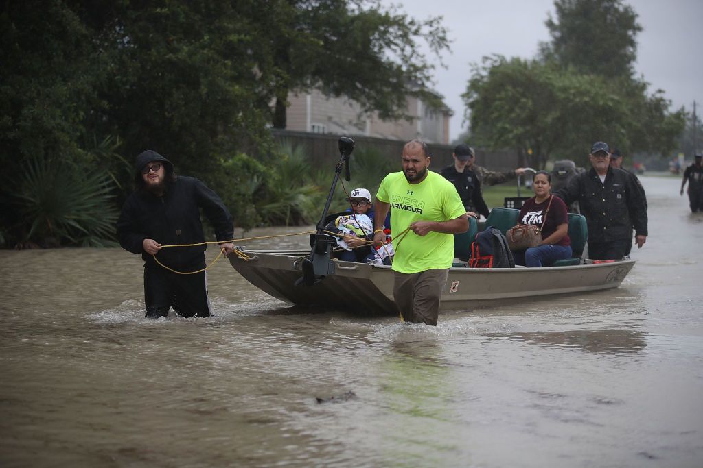 People in Houston walk down a flooded street on Aug. 28, 2017 as Tropical Storm Harvey drives them out of their homes.