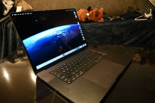 Angled photo of a MacBook Pro 16-inch (M3 Max, 2023) open on a coffee table