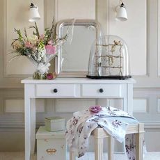 white dressing table with white wall and white frame mirror