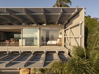 bridge house, a residence open towards sea views via glazed facade and metal structure framing the openings out to the sea