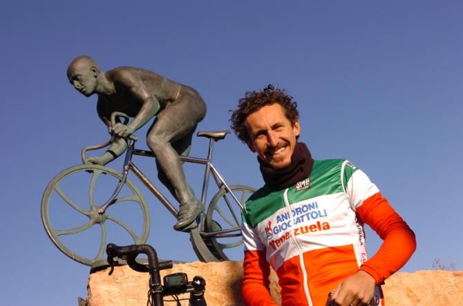 Pellizotti keeps warm while standing in front of the Pantani memorial