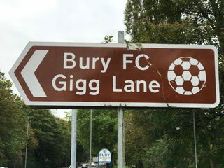 A road sign pointing to Bury's Gigg Lane ground