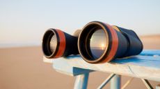 binoculars on a table with the sun reflected in the lenses