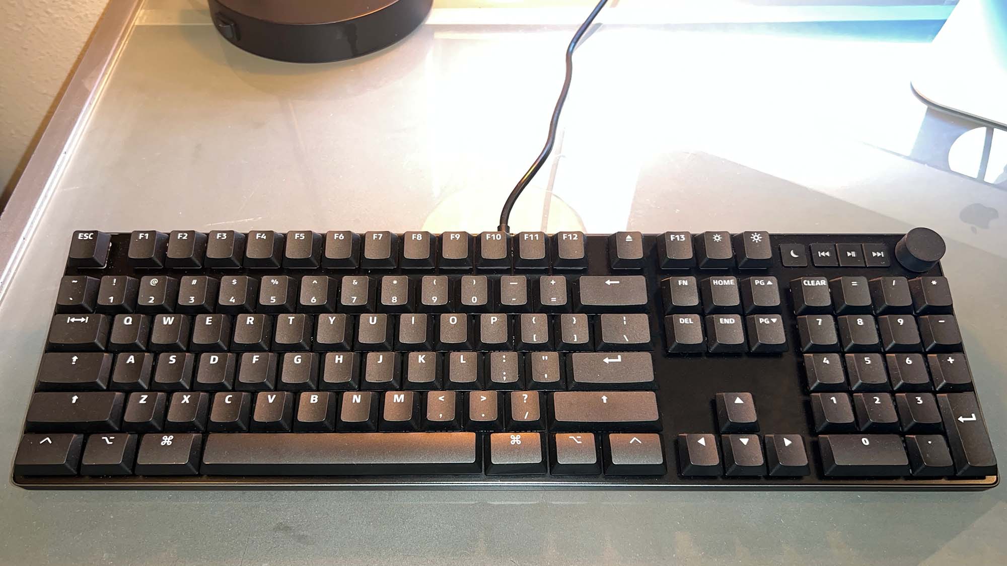 A Das Keyboard MacTigr on a glass-top desk