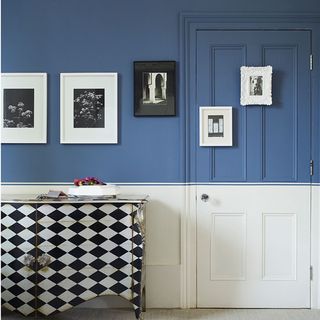 room with half painted door and blue wall