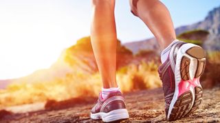 Running shoes on sale. Shown here, a close-up of a person running and her running shoes.